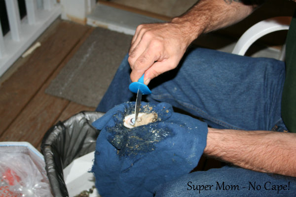 Slide the shucking tool under the oyster and cut it away from the shell. Leave the oyster on the half shell.