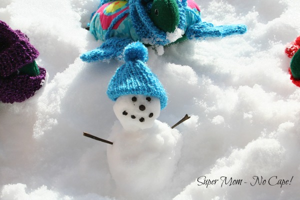 Miniature snowman wearing Lexie's knitted hat.
