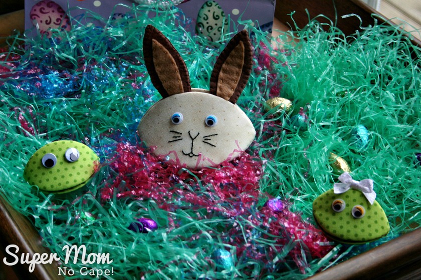 Photo of Bennet Bunny, Frankie and Frannie Frog on a bed of Easter Grass with foil wrapped chocolate eggs scattered around