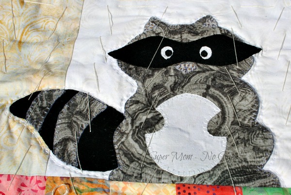 Hand quilting done around the appliqued raccoon.
