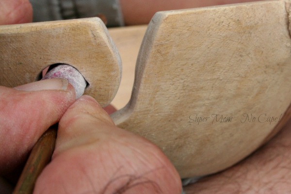 Sanding the opening using 180 grit sandpaper wrapped around a metal rod