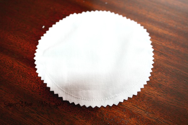 White circle of fabric that has been trimmed with pinking shears.
