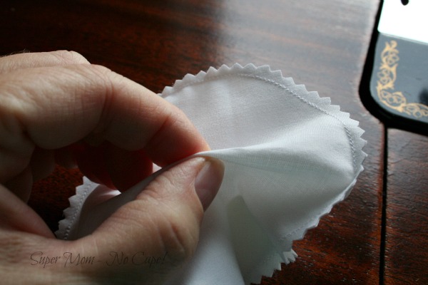 Showing how to pull the layer of fabric apart on the white fabric circle