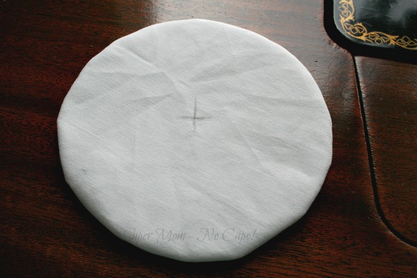White fabric circle turned right side out with an X drawn in the center of the circle.