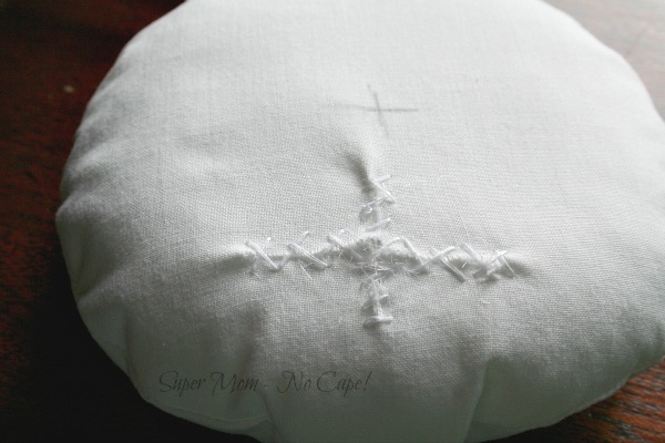 The stuffed white fabric circle with the opening whipstitched closed.