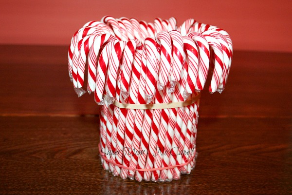 Insert Candy canes between rubber band and vase