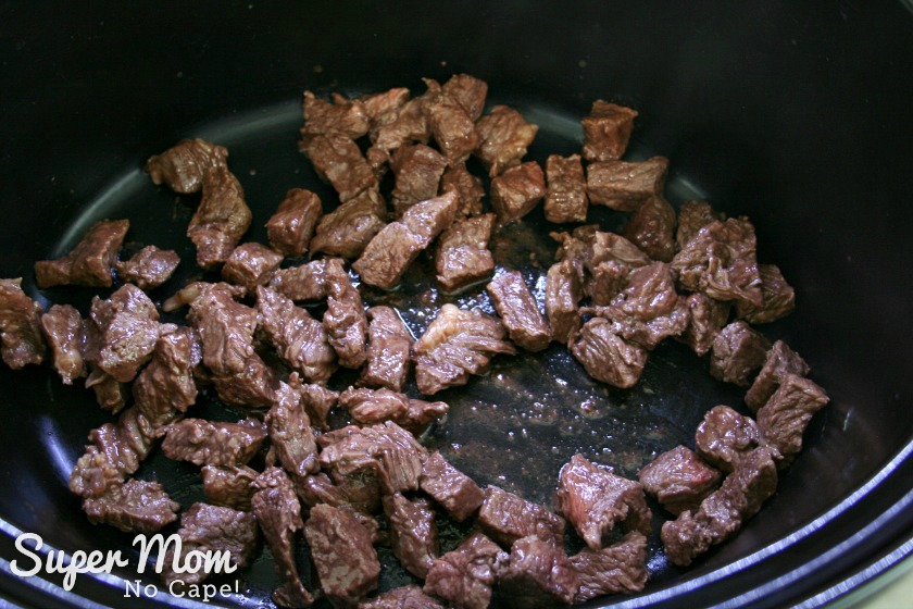 Browned beef pieces added to the slow cooker.