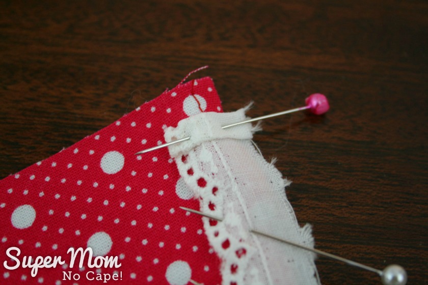 Photo showing the end of eyelet trim folded over twice and pinned.