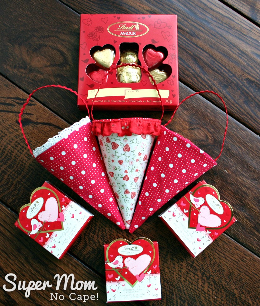 Photo of three fabric cones laying on a dark wood table with Lindt Valentine's chocolate packages.