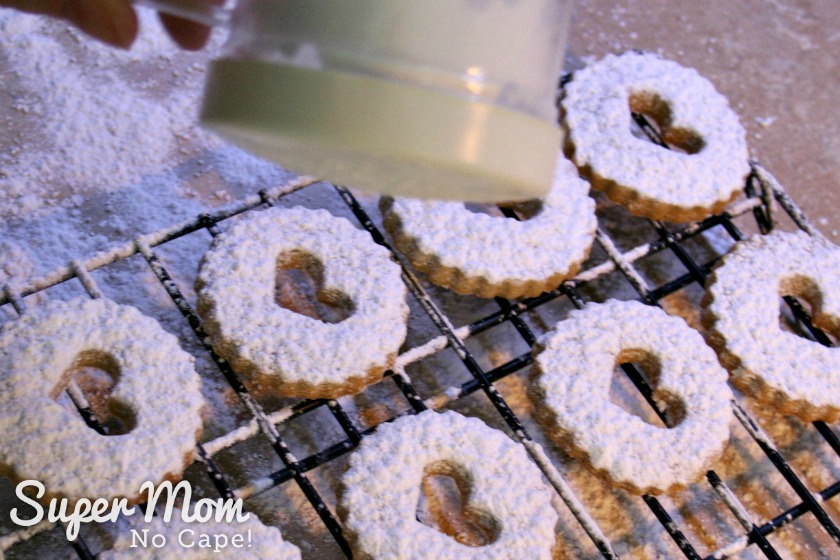 Photo of icing sugar being shaken on to the top of the Snow Storm Linzer Cookies