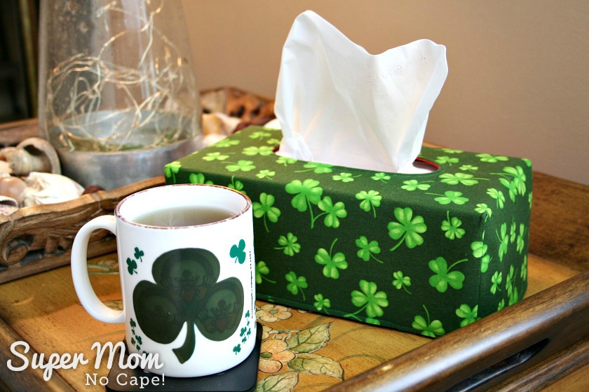 Large shamock fabric tissue box cover on living room side table pictured with a cup of tea