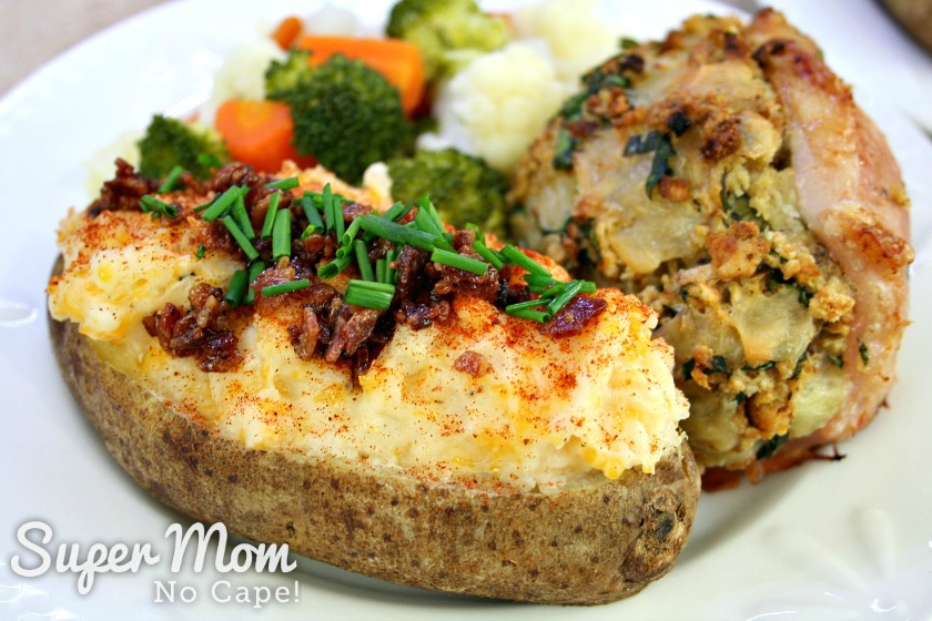Twice Baked Potato served with stuffed pork loin chop and steamed veggies