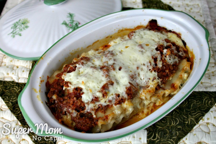 Make these Easy Lasagna Roll Ups for supper tonight or freeze them to have for those nights when life gets a little crazy and you don't have time to cook. Freezer cooking is a sanity saver and this recipe is a family favorite that you'll want to make again and again. #recipes #freezercooking #lasagnarecipes #lasagna #pastarecipes Two Lasagna Roll Ups in casserole dish after baking