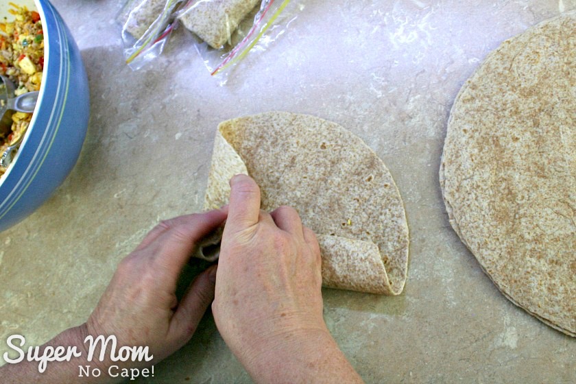 Folding over the left hand side of the tortilla