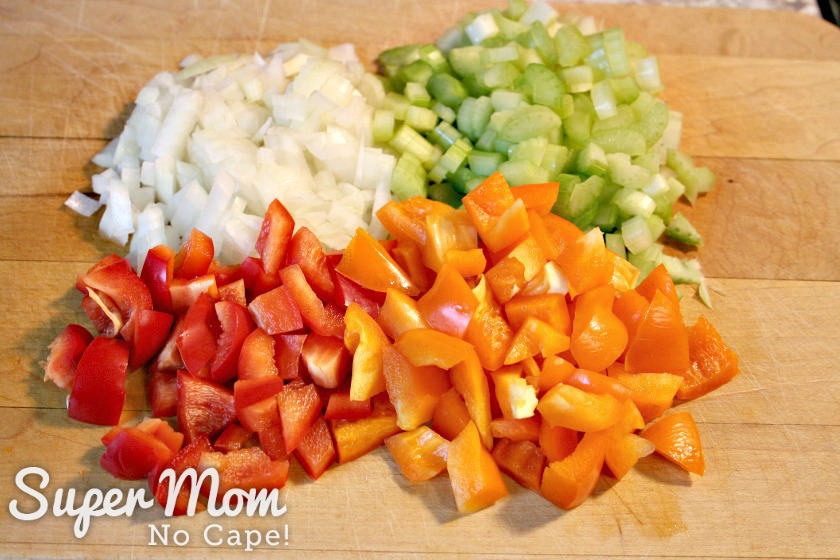 Chopped onions, celery and red and yellow peppers for Super Mom's Jambalaya on a cutting board