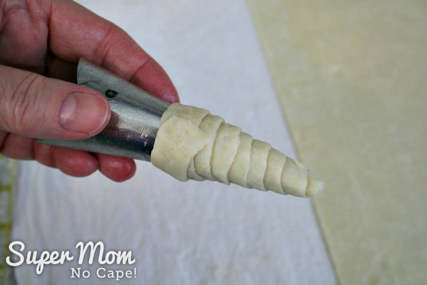 Wrap the end of the puff pastry strip around the top of the puff pastry cone