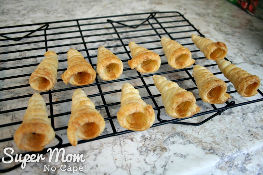 Mini puff pastry cones cooling on a rack