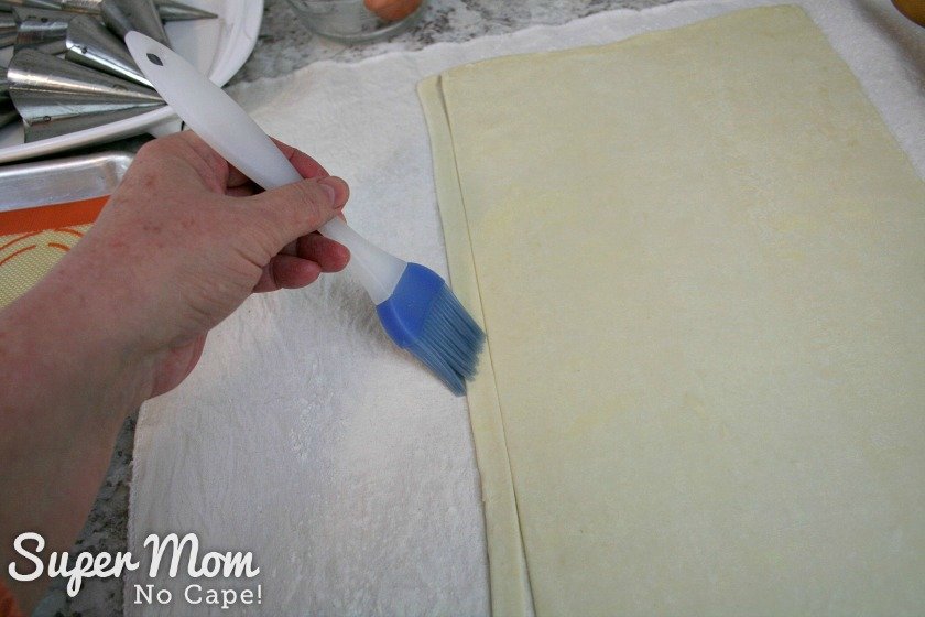 Brush the strip of puff pastry with water