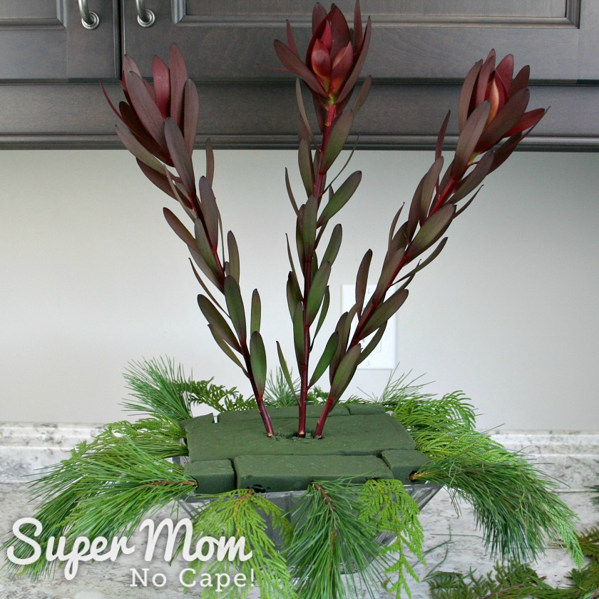 Dark red leaf spike added to the center of the DIY Christmas floral arrangement