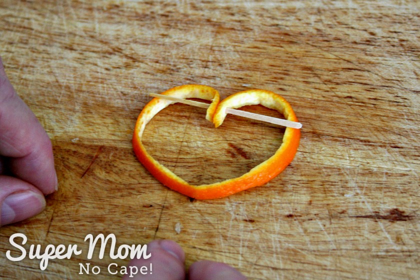 Orange rind with toothpick inserted into both ends to make a heart garnish for the Cosmo cocktailOrange rind with toothpick inserted into both ends to make a heart garnish for the Cosmo cocktail