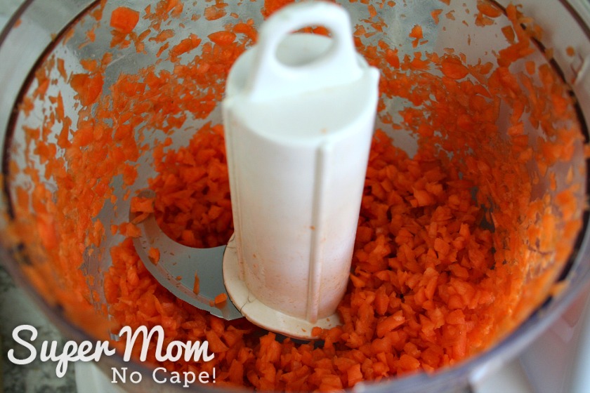 Bowl of food processor with finely chopped carrots