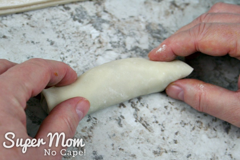 Finishing rolling the egg roll by hand