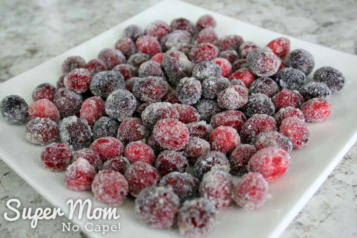 Lots of sugared cranberries on a square white plate