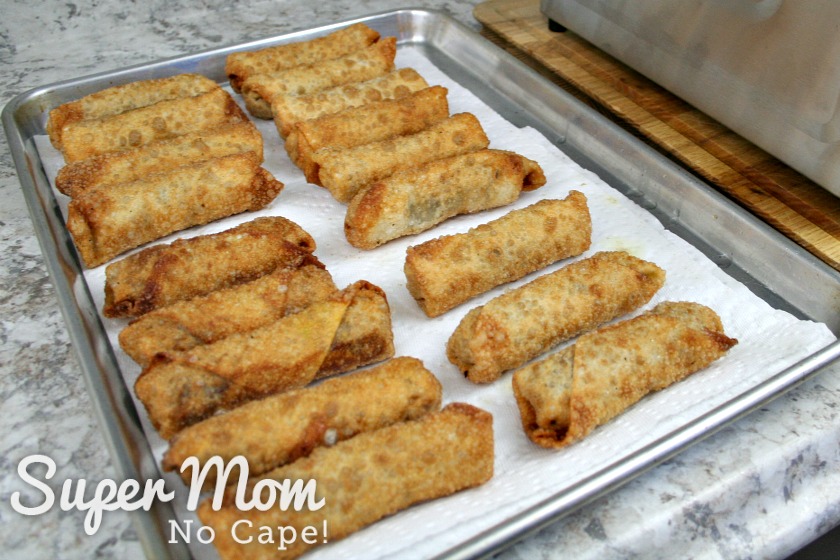 Tray lined with paper towel with 18 fried homemade egg rolls