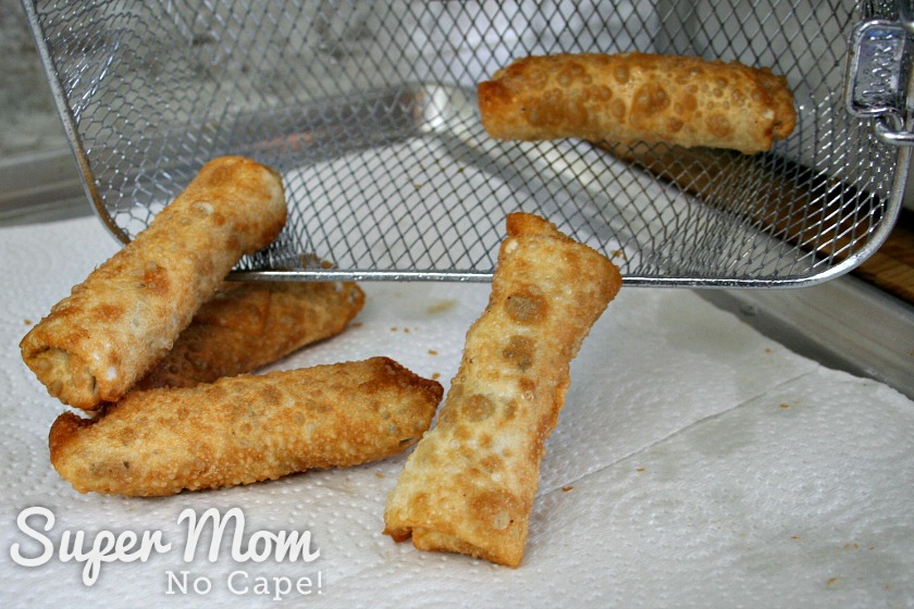 Turning the egg rolls out onto paper towel