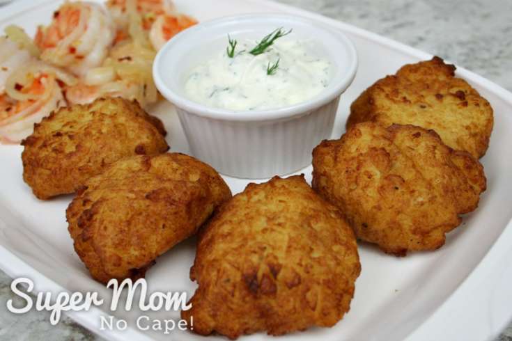 Five Rustic Potato Puffs on platter with bowl of dip and pan fried shrimp in the background