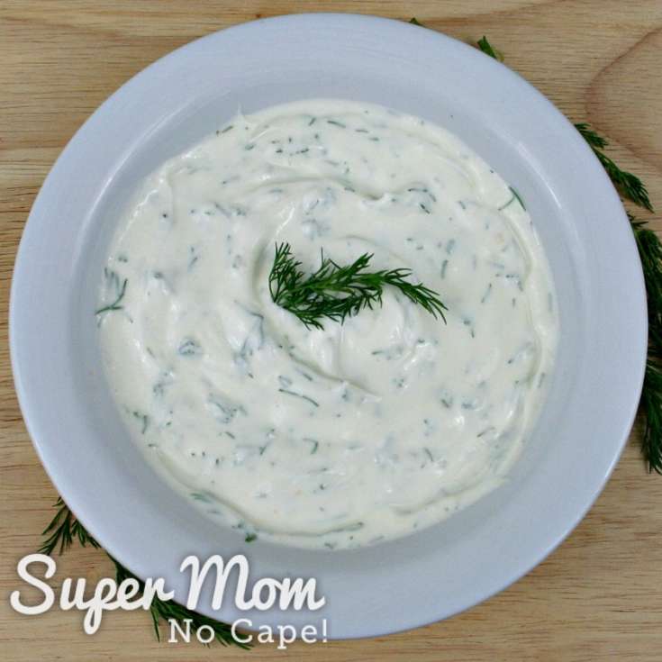 Overhead photo of Dilly Greek Yogurt Dip in a white bowl on a cutting board