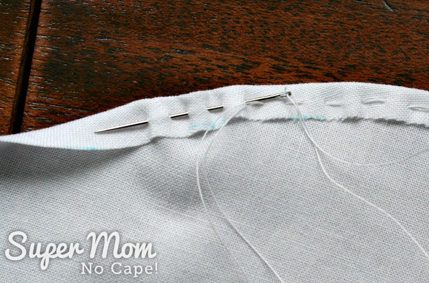 Running stitches along the edge of the fabric circle