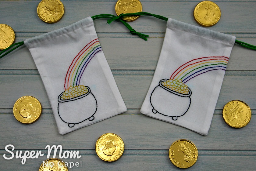 Two small drawstring bags with embroidery pattern of pot of gold at the end of the rainbow