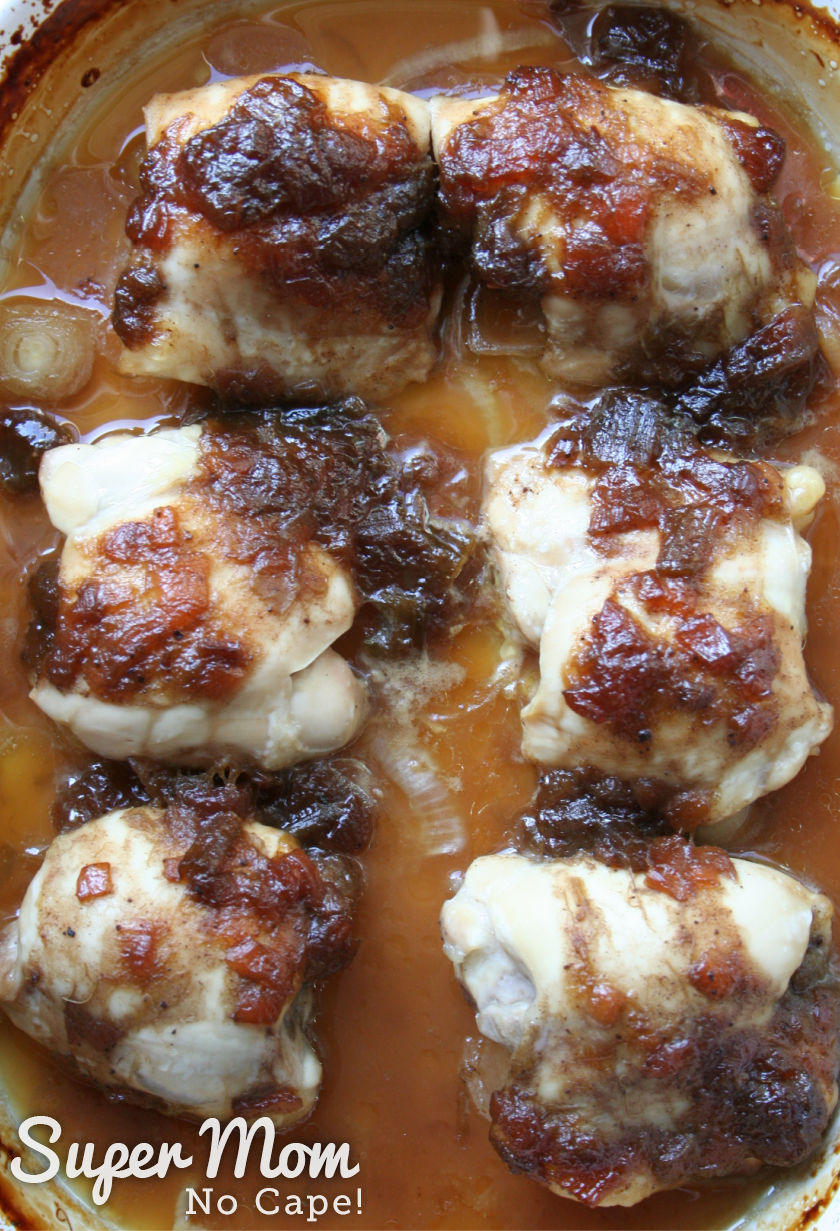 6 baked chicken thighs in a white baking dish with juices from baking and rhubarb relish.