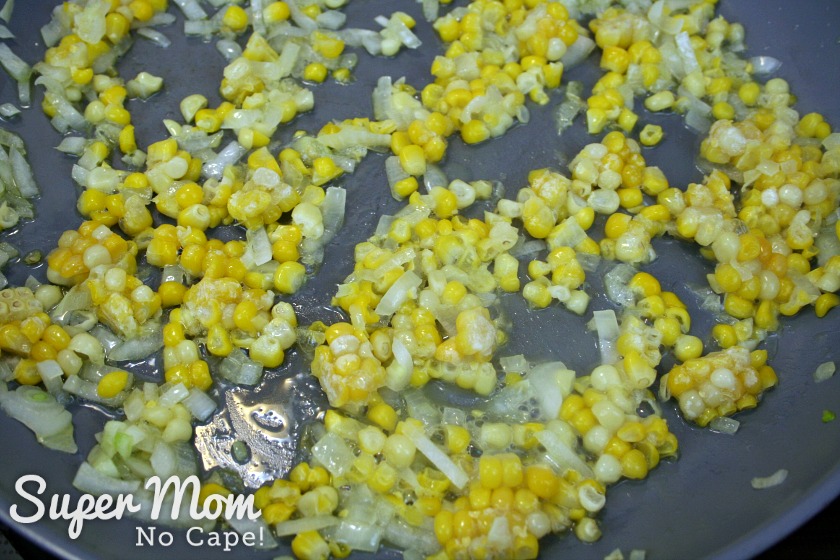 A picture of adding corn to the frying onions for the filling of the turkey enchilada tart