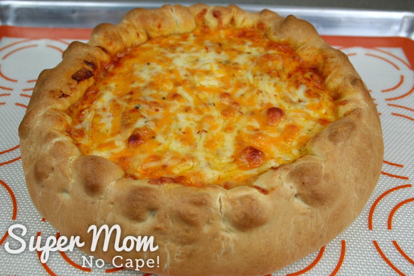 A baked turkey enchilada tart on a baking sheet lined with a silicone baking mat.