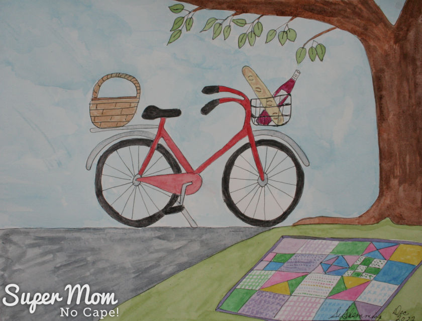 Photo of June's Calendar Page - Watercolor painting of a bike beside a tree with picnic quilt spread on the ground.