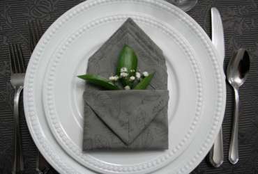 Image of folded napkin on plate with greenery