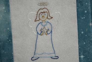 Prudence Angel Embroidery Pattern stitched on white sparkly fabric